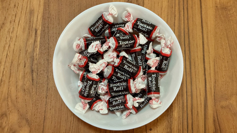 A white bowl filled with wrapped Tootsie Rolls