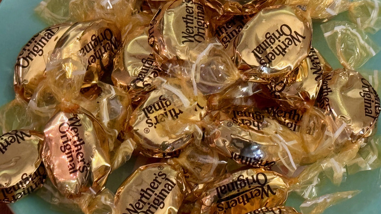 Gold wrapped Werther's Originals piled on a blue plate