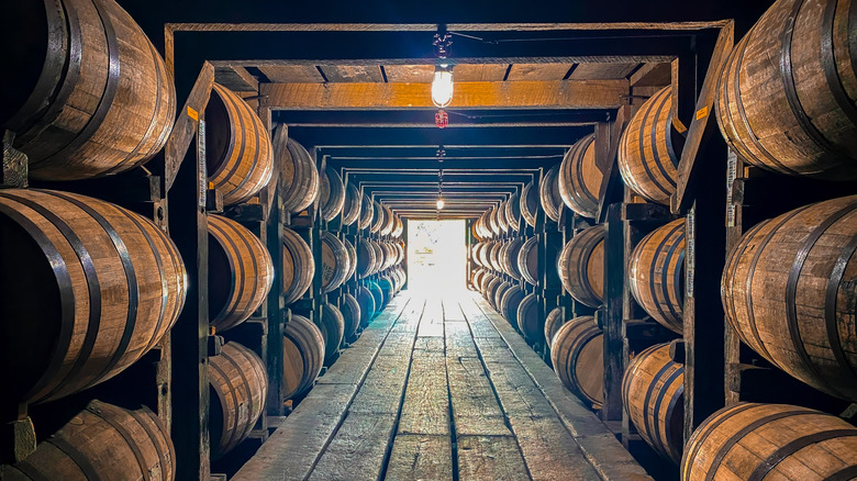 stacked oak barrels of aging bourbon