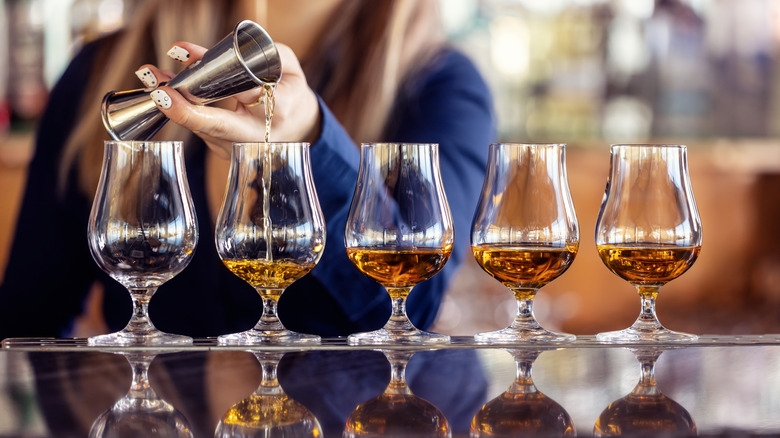 a flight of whiskey being poured