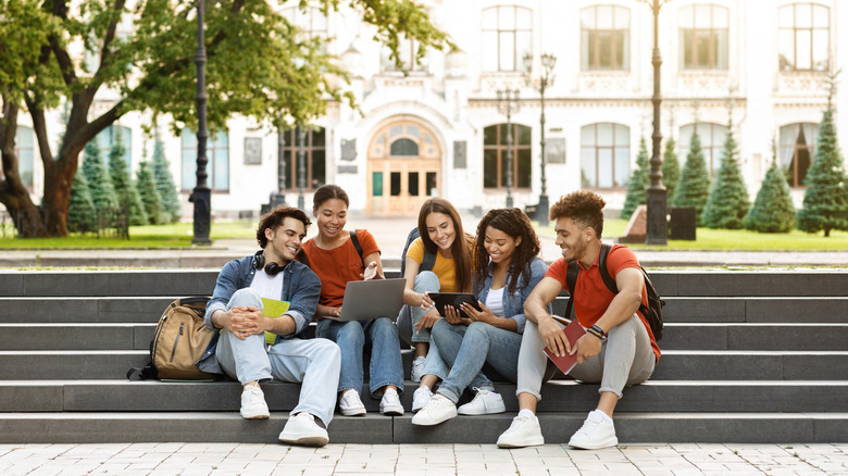 students looking at computers outside
