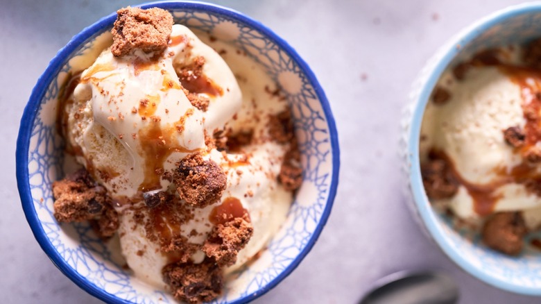 Vanilla ice cream in blue dishes with golden streusel crumbled on top