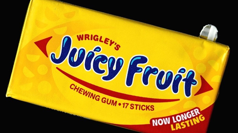 A pack of Wrigley's Juicy Fruit chewing gum on a black background.