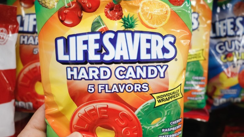 A hand holding a bag of Life Savers hard candy.