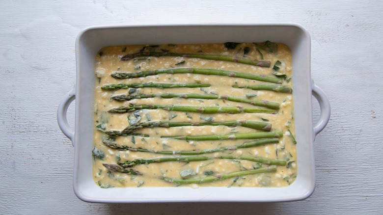 Unbaked egg bake with asparagus spears on top