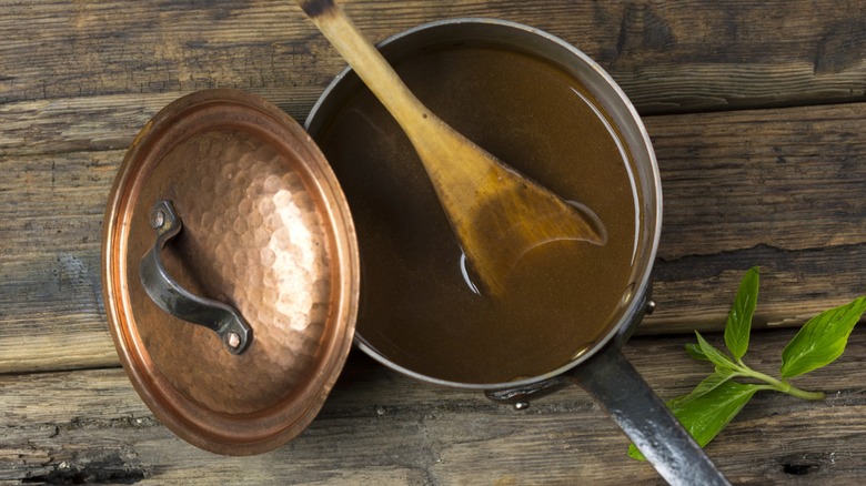 Gravy in copper pot on wood table