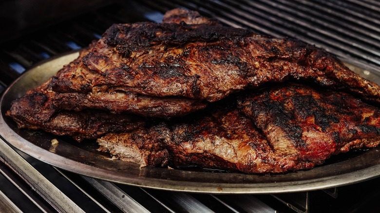 Overcooked steak on a plate over grill