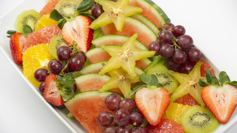 An assorted fruit platter with watermelon, grapes, kiwi, and strawberries