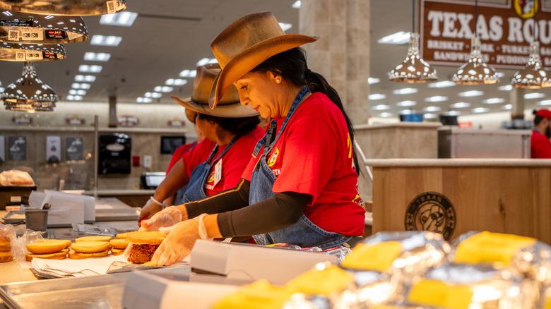 Workers make sandwiches at Buc-ee's barbecue station inside the store