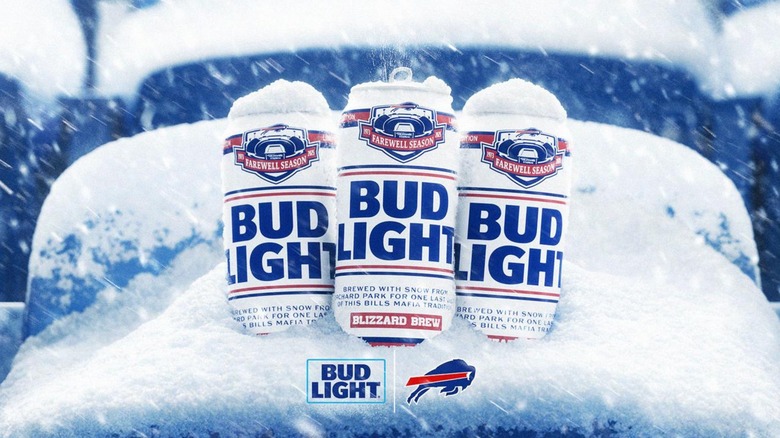 Three cans of the specialty Bud Light Blizzard Brew covered in snow in a stadium seat