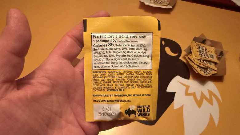 Hand holding a Poppin' Ranch packet showing the nutrition information on the back