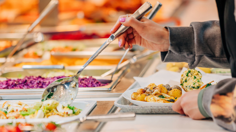 Woman's arm grabbing food at buffet