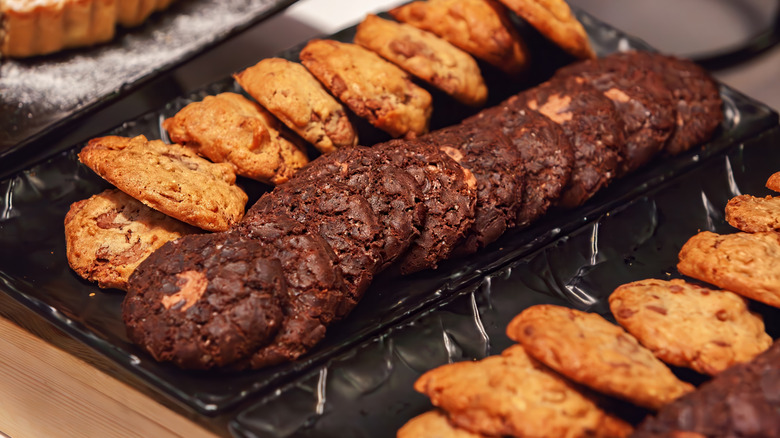 Several rows of cookies on black plates, served at a buffet.