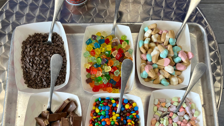 Several trays with spoons in them sit in two rows of three.