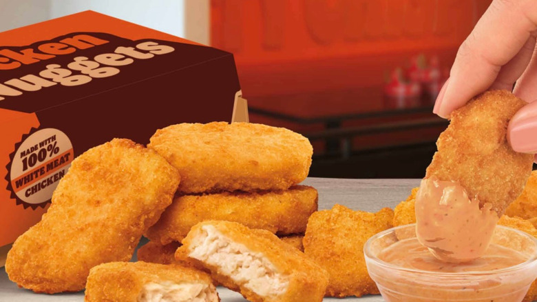 Hand dipping Burger King new nuggets in new sauce.