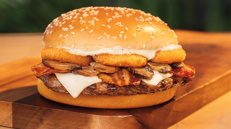 The Burger King Ultimate Steakhouse Whopper with onion rings, bacon, mushrooms, and Swiss cheese on a sesame seed bun