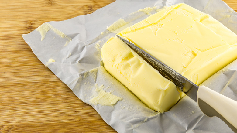 freshly opened block of butter with knife