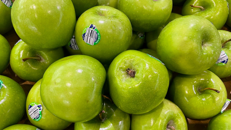 Close up of green apples with produce stickers