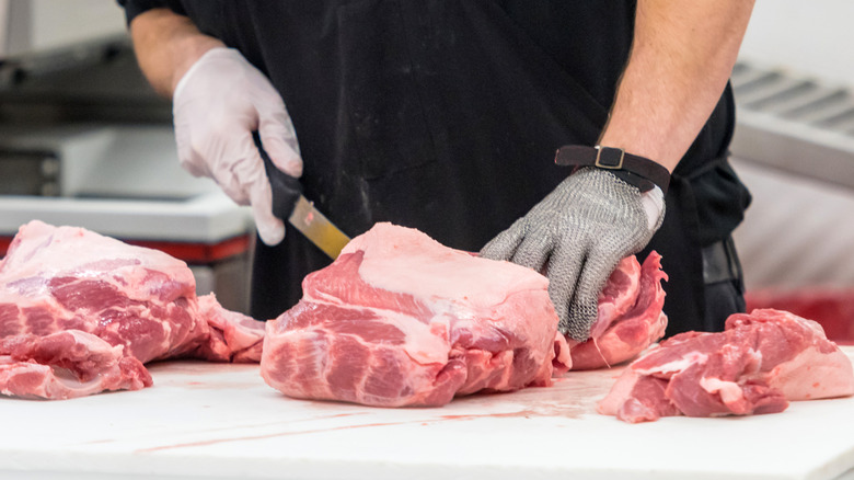 A butcher portions meat into sections
