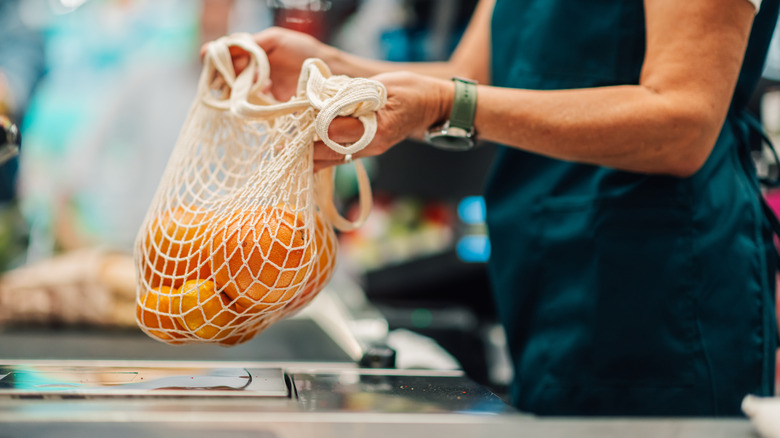 grocery store cashier with oranges