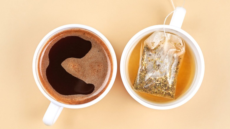 Two cups, one of which contains coffee and another that contains tea.
