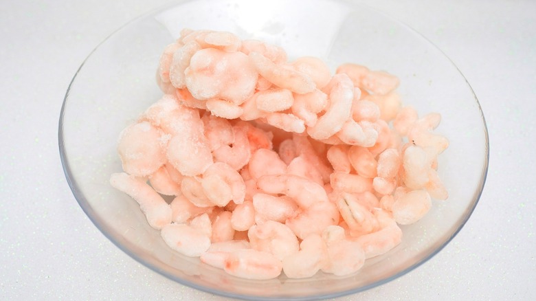 Pink frozen shrimp in a glass bowl