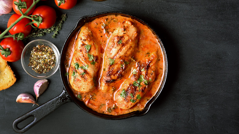 Chicken breast in creamy tomato sauce in cast iron pan