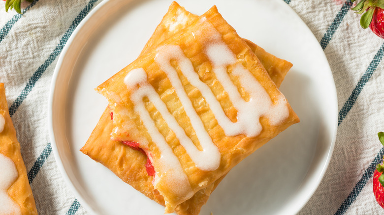 One partially consumed toaster strudel is stacked on top of another on a plate