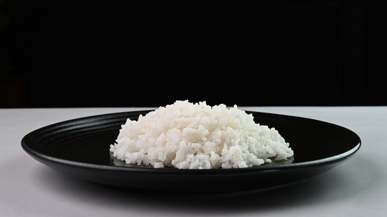 White rice piled on a black plate.