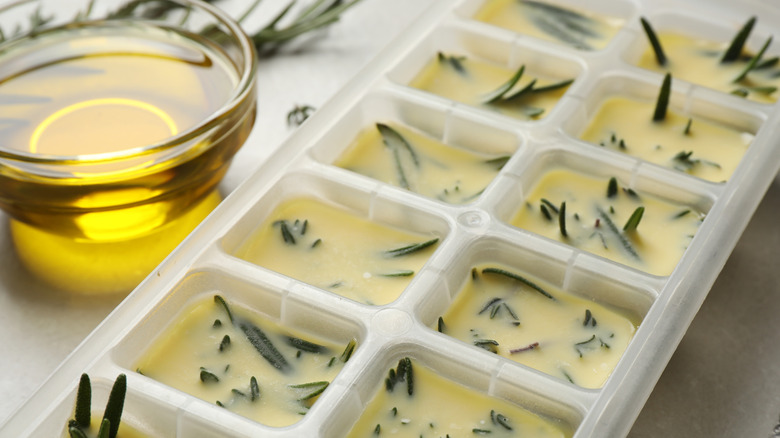 Ice cube tray with olive oil and herbs frozen inside