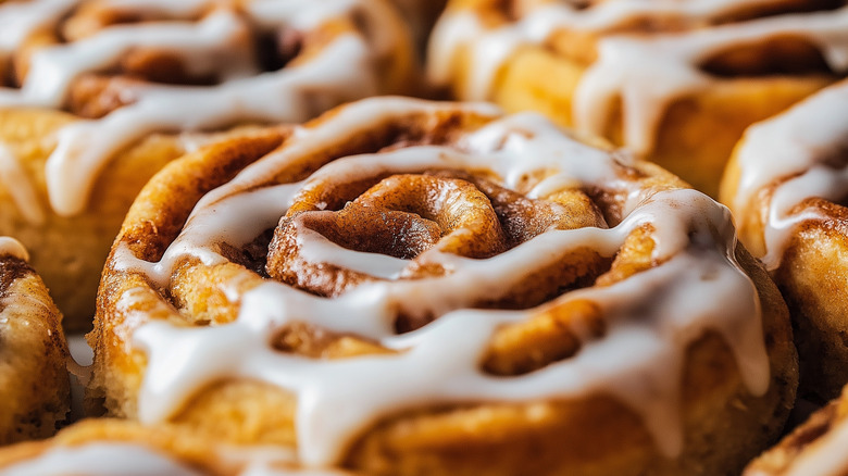 Several golden cinnamon rolls with white icing