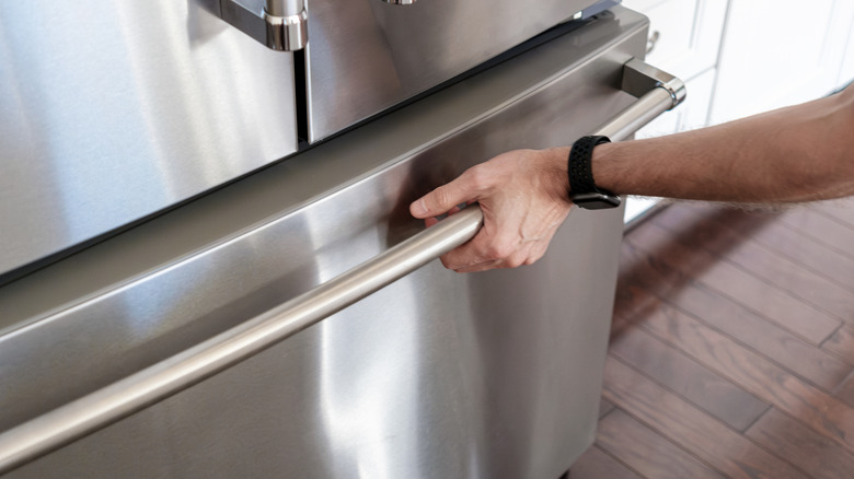A man pulling open the freezer door