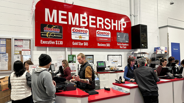 People standing at a Costco membership desk