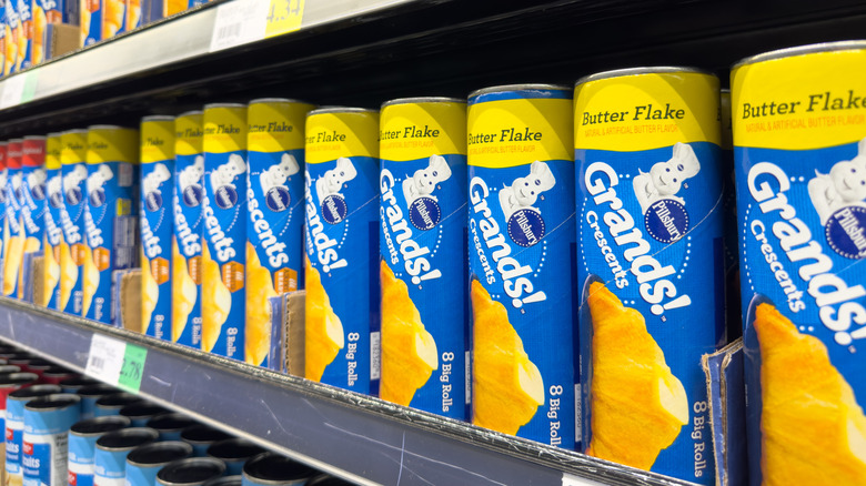 Cans of canned crescent rolls on store shelf