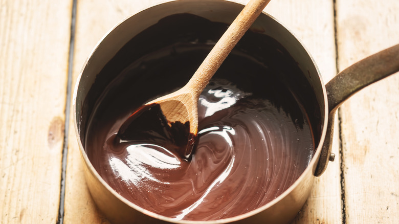 Chocolate sauce in a pan with a wooden spoon