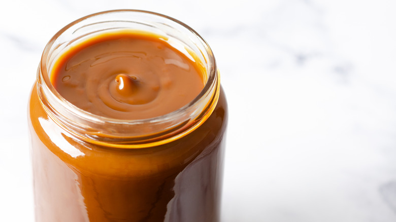 A glass jar of dulce de leche sauce