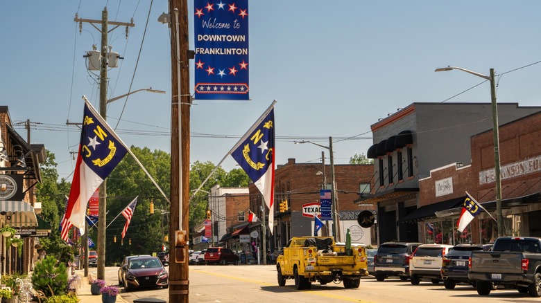 North Carolina state flags and historic storefronts along Main Street in downtown Franklinton.
