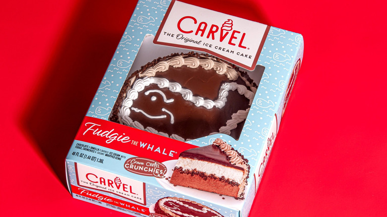 Fudgie the Whale Carvel ice cream cake in box on red background.