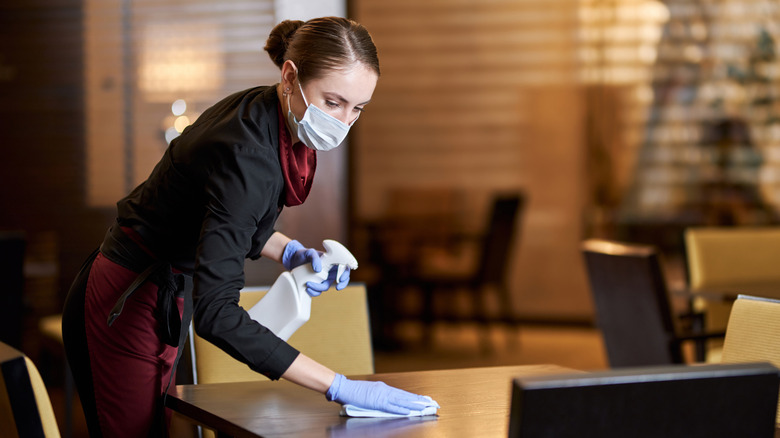 Restaurant server cleaning table