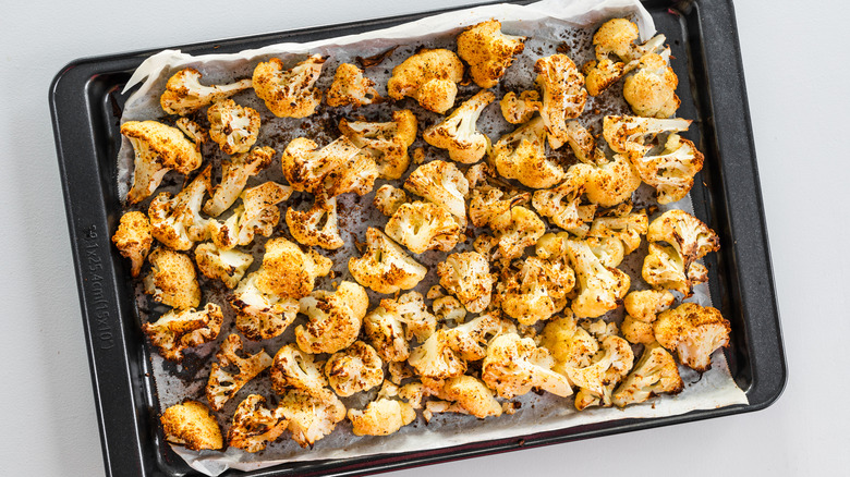 A baking sheet of roasted cauliflower florets, shot from above