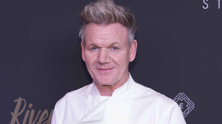 Gordon Ramsay smiles in a chef's jacket at an event