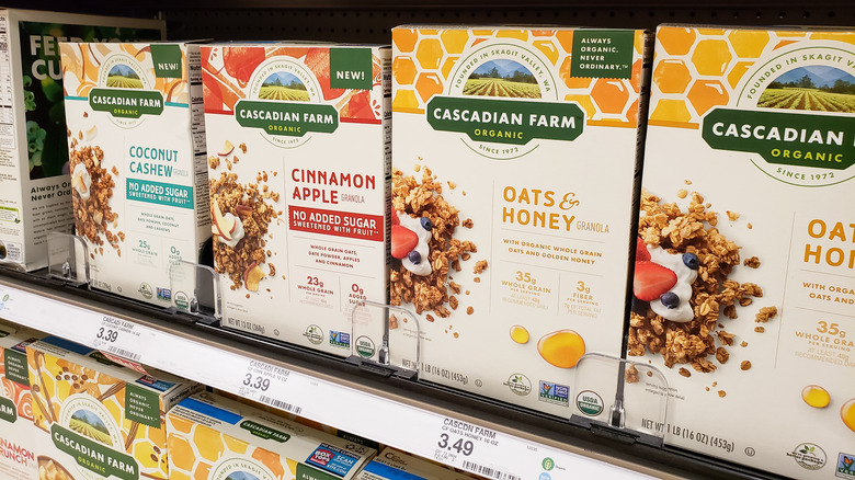 Several boxes of Cascadian Farms granola in the cereal aisle of a grocery store