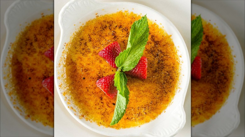 Creme brulee dessert with caramel crust, berries, and mint
