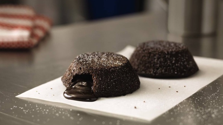Two small chocolate lava cakes on silver tabletop