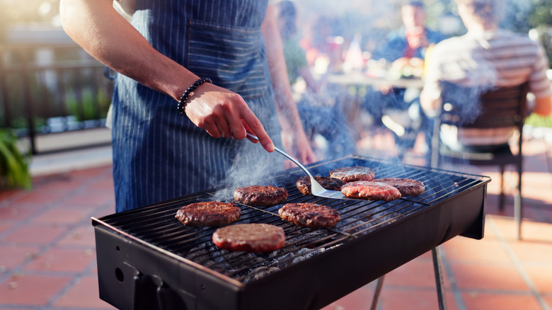 Man grilling burger patties