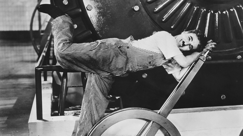 Charlie Chaplin posing with one leg in air