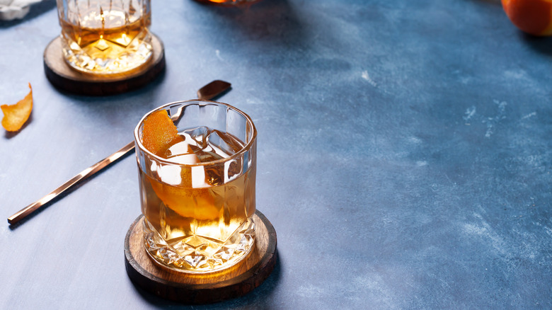 Cocktail glasses with orange peel on a blue tabletop