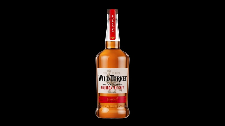 Bottle of Wild Turkey bourbon with mirrored sepia bottles