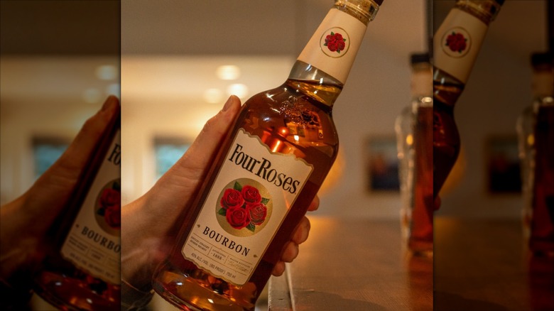 Bottle of Four Roses bourbon on a table with glass and record player