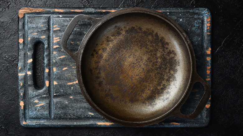 A vintage cast iron pan on a black serving board